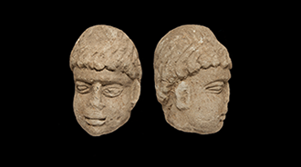 Front and side view of a stone head found during excavations at Binchester Roman Fort