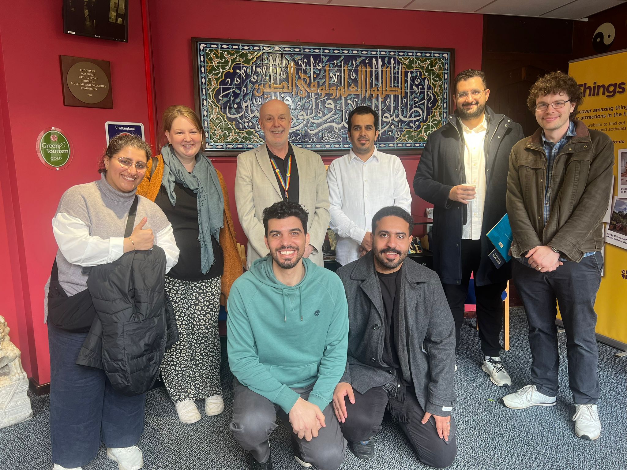 Group photo of smiling guests from the Saudi Heritage Commission and members of the Department of Archaeology at the Oriental Museum with Dr Craig Barclay, Head of Museums, Galleries and Exhibitions Team at Durham University.