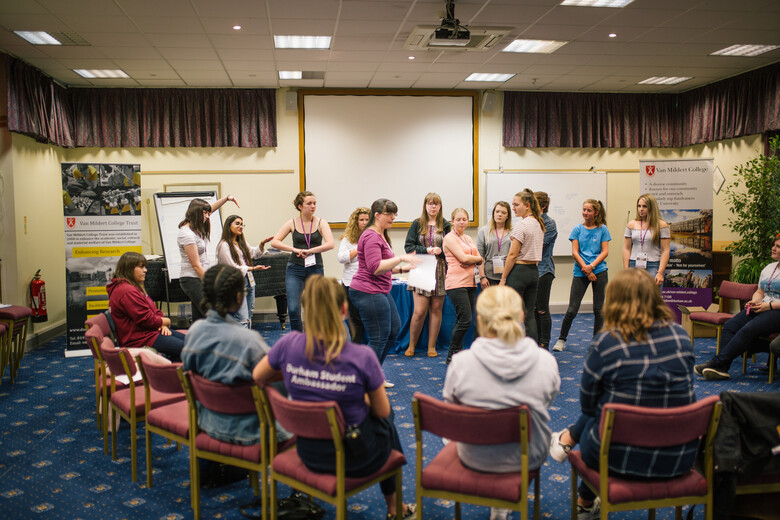 Students sitting and standing in a circle