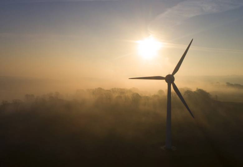 A windmill silhouetted against the sky at dawn