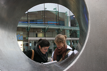 Geography students seen through a circular architectural feature