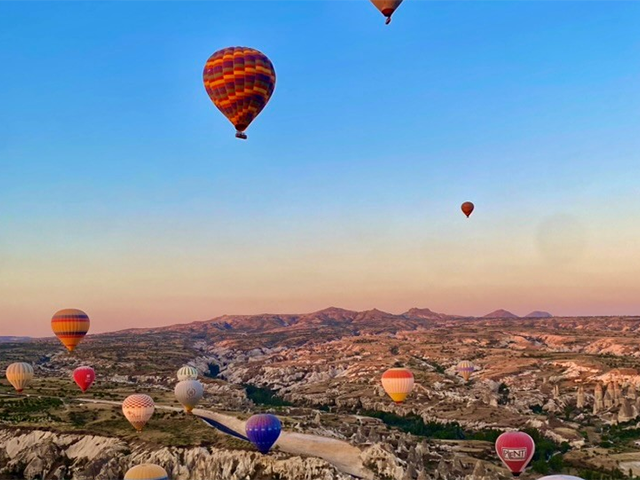 Hot air balloons over rocky landscape