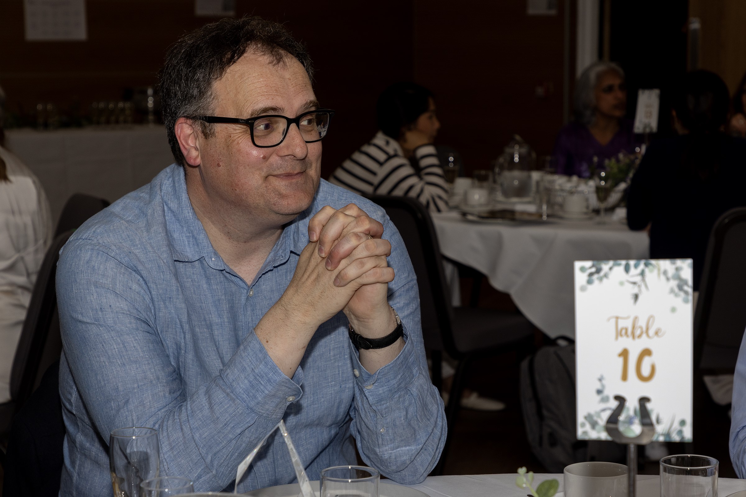 A man sitting and smiling at a table