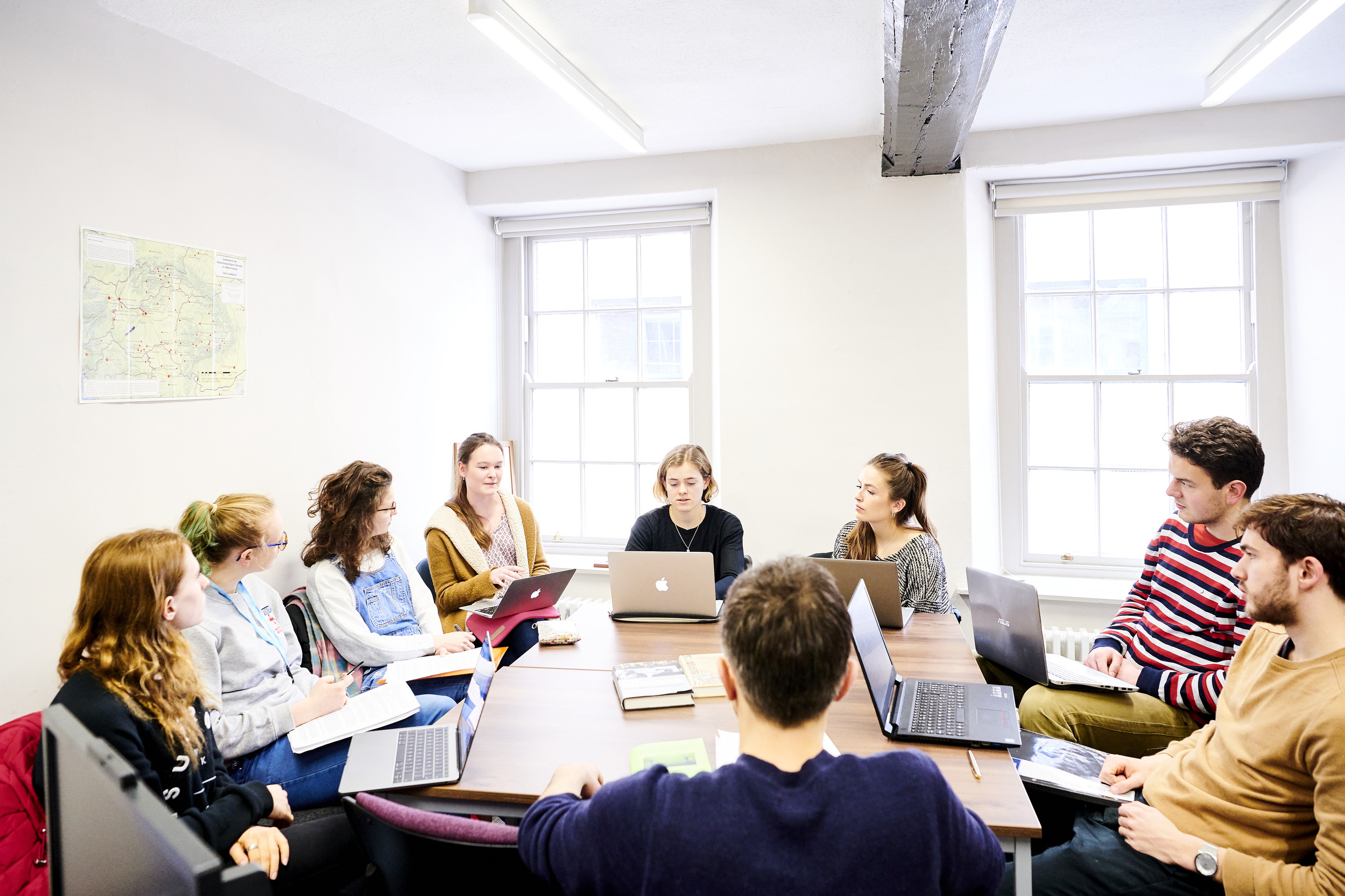 Students sat round a table with laptops