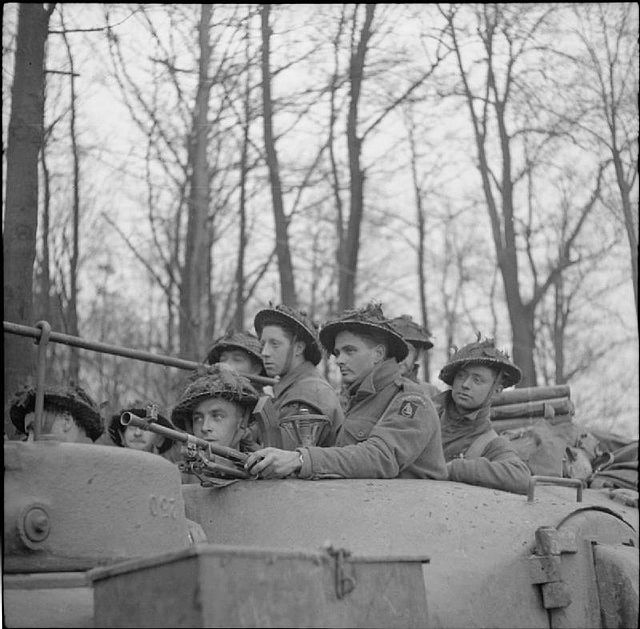 A black and white image of soldiers from the Durham Light Infantry in a tank in a wooded area