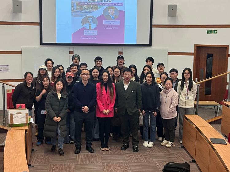 Around 30 people smiling at the camera at the