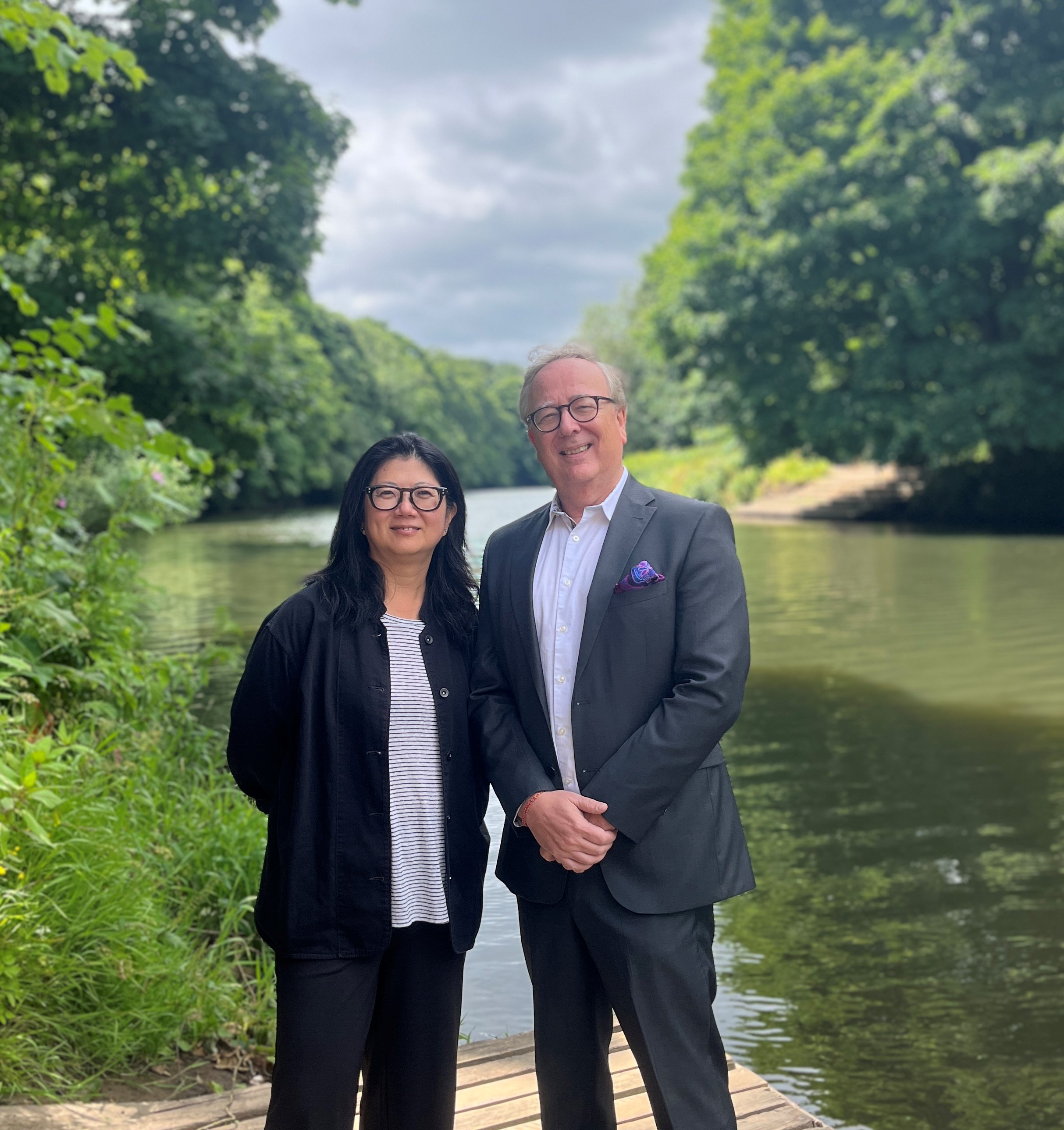 Rosi Song and Daniel Newman stand in front of a river