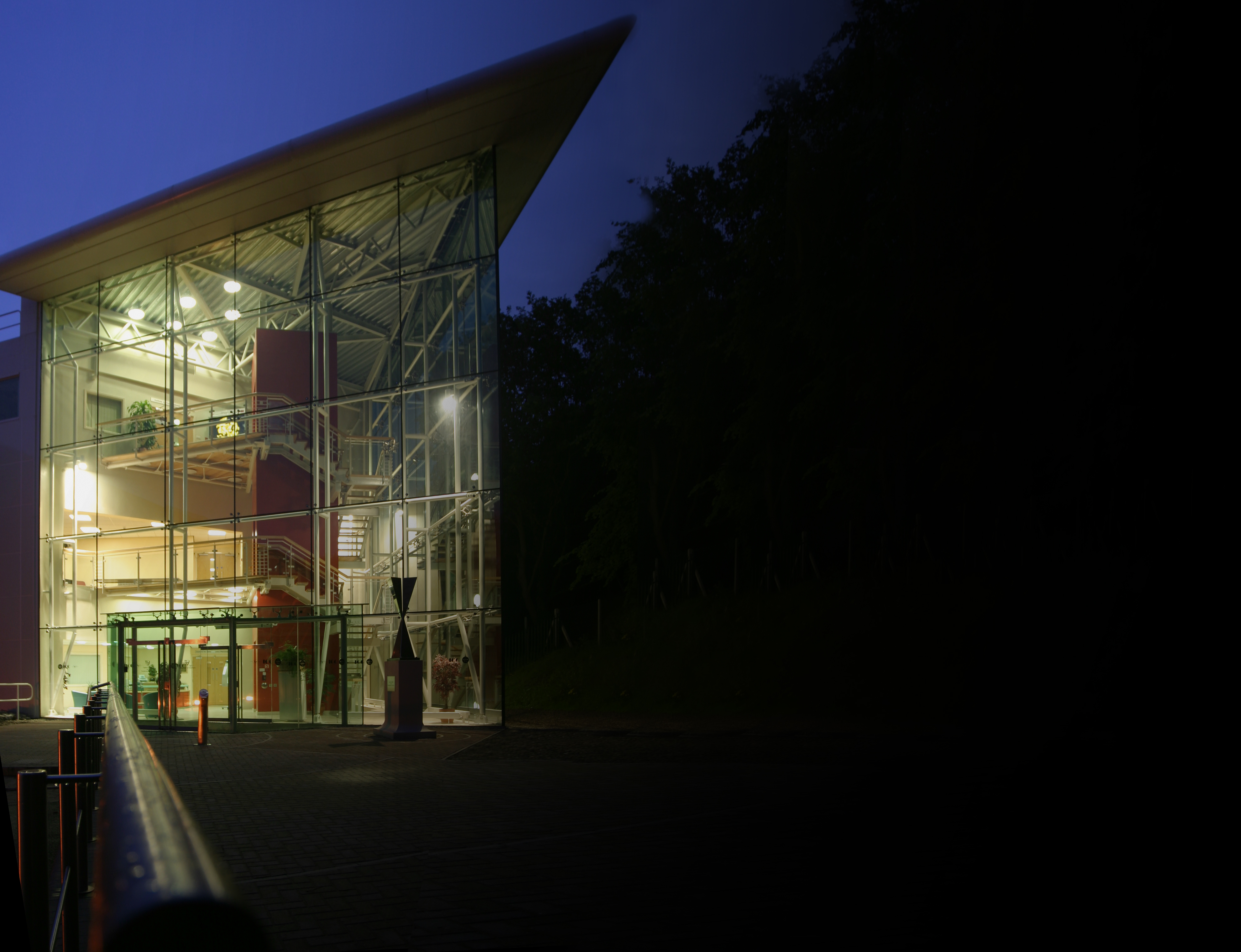 Glassy side elevation of Ogden East at night lit up, showing the lobby and stair tower