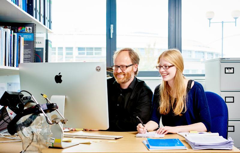 Two researchers analysing data at computer workstation