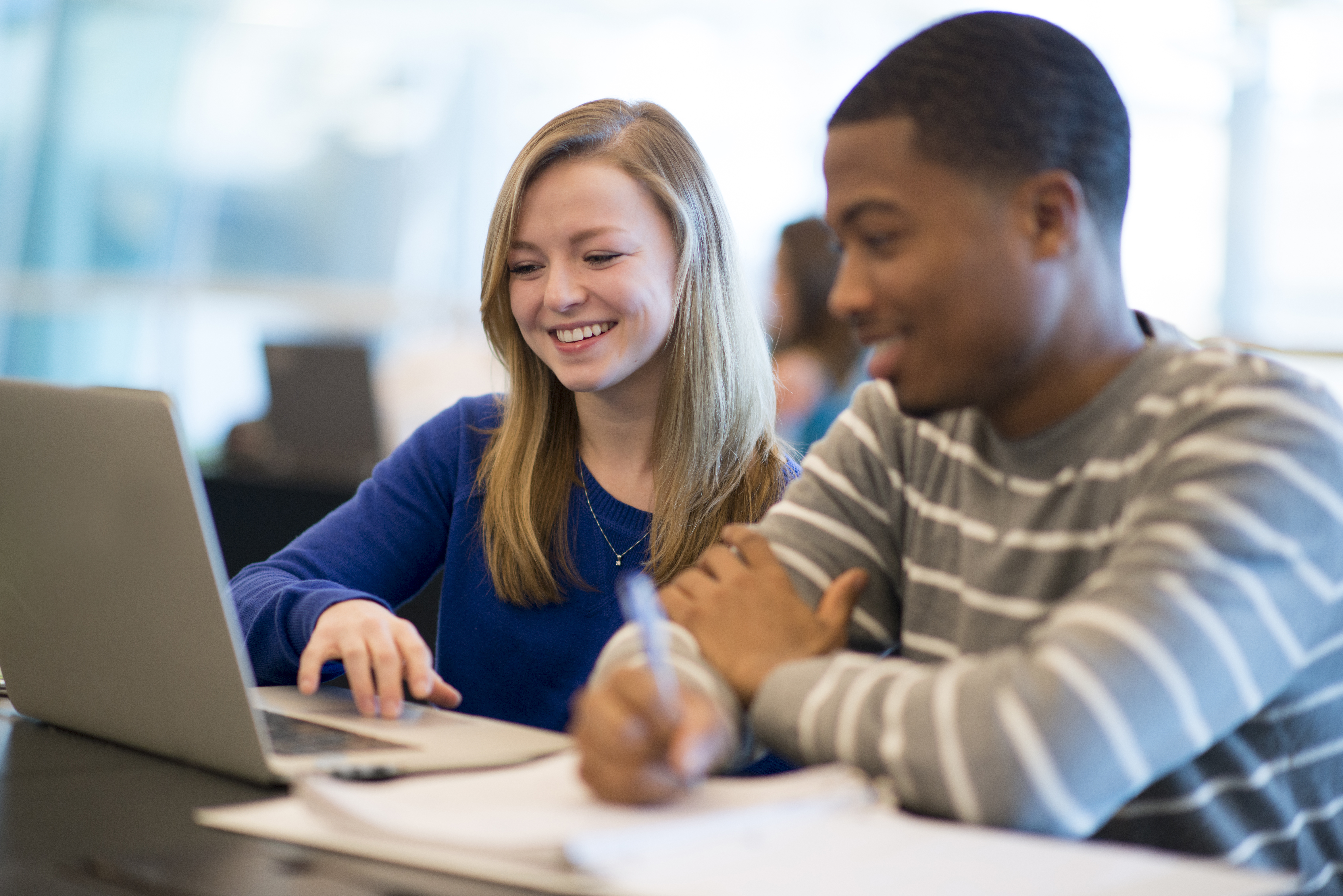 Two students working together on laptop