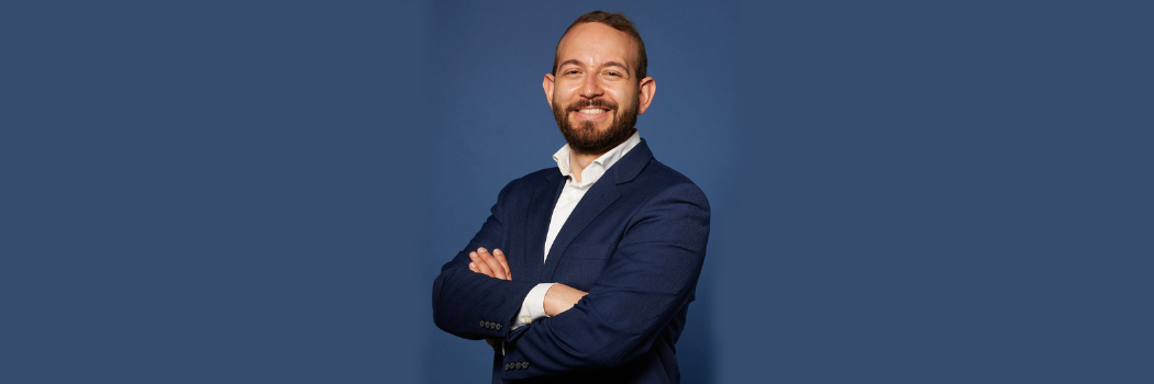 Image of Assistant Professor Omar Hammoud-Galleg standing in front of a blue backdrop.