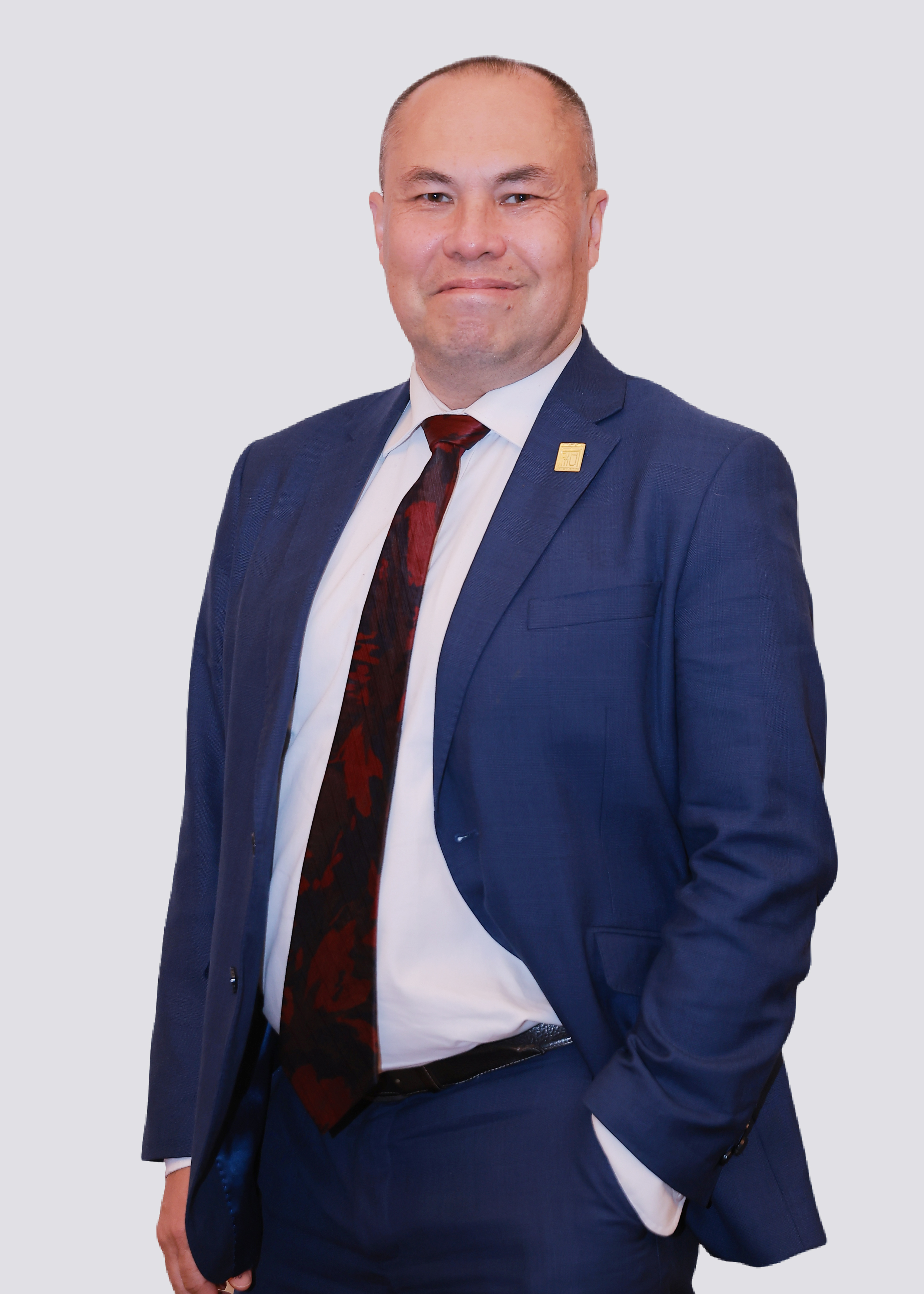 Warwick Powell smiling in blue suit in front of white background