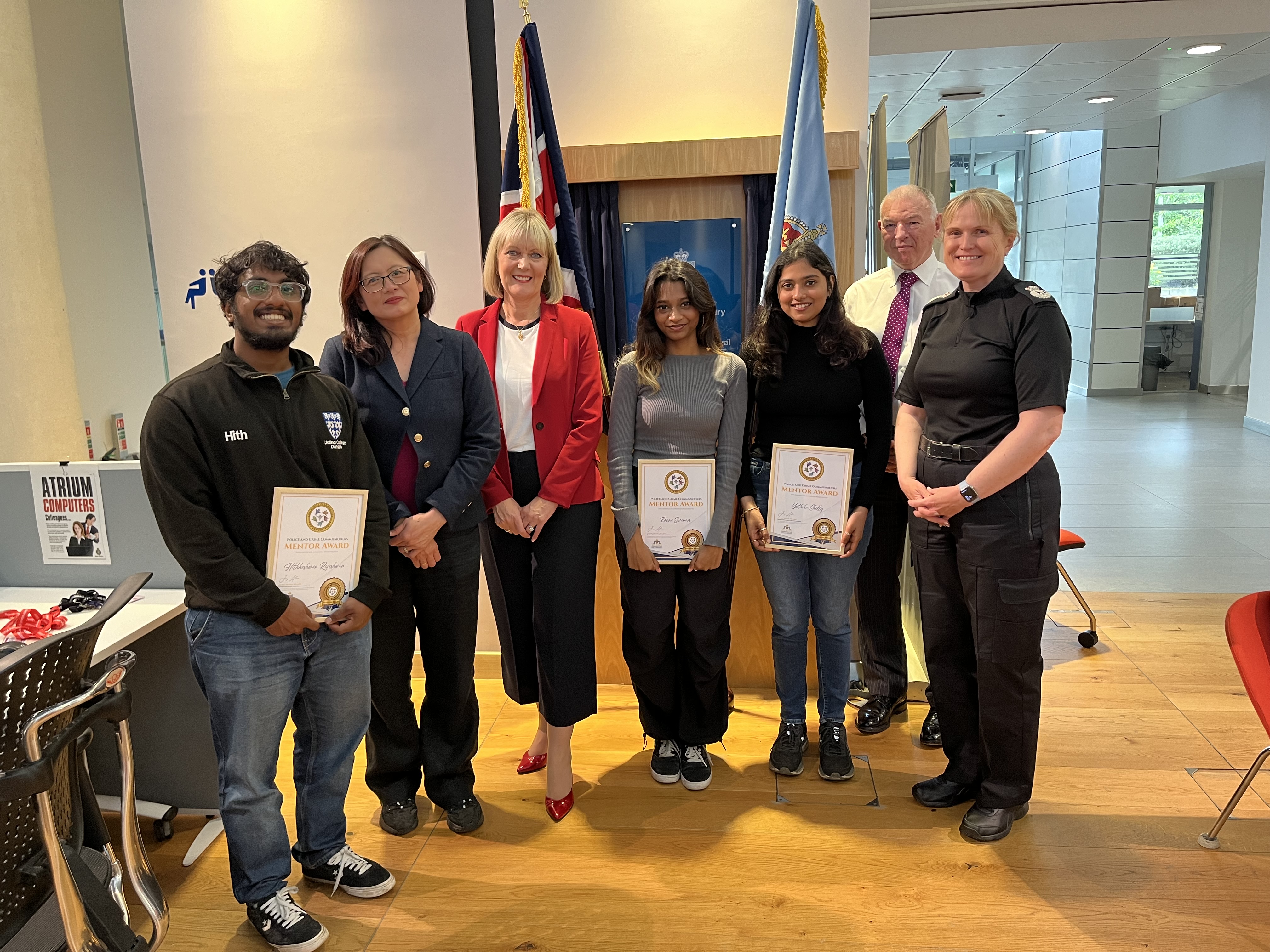 Students and colleagues stand with their certificates facing the camera