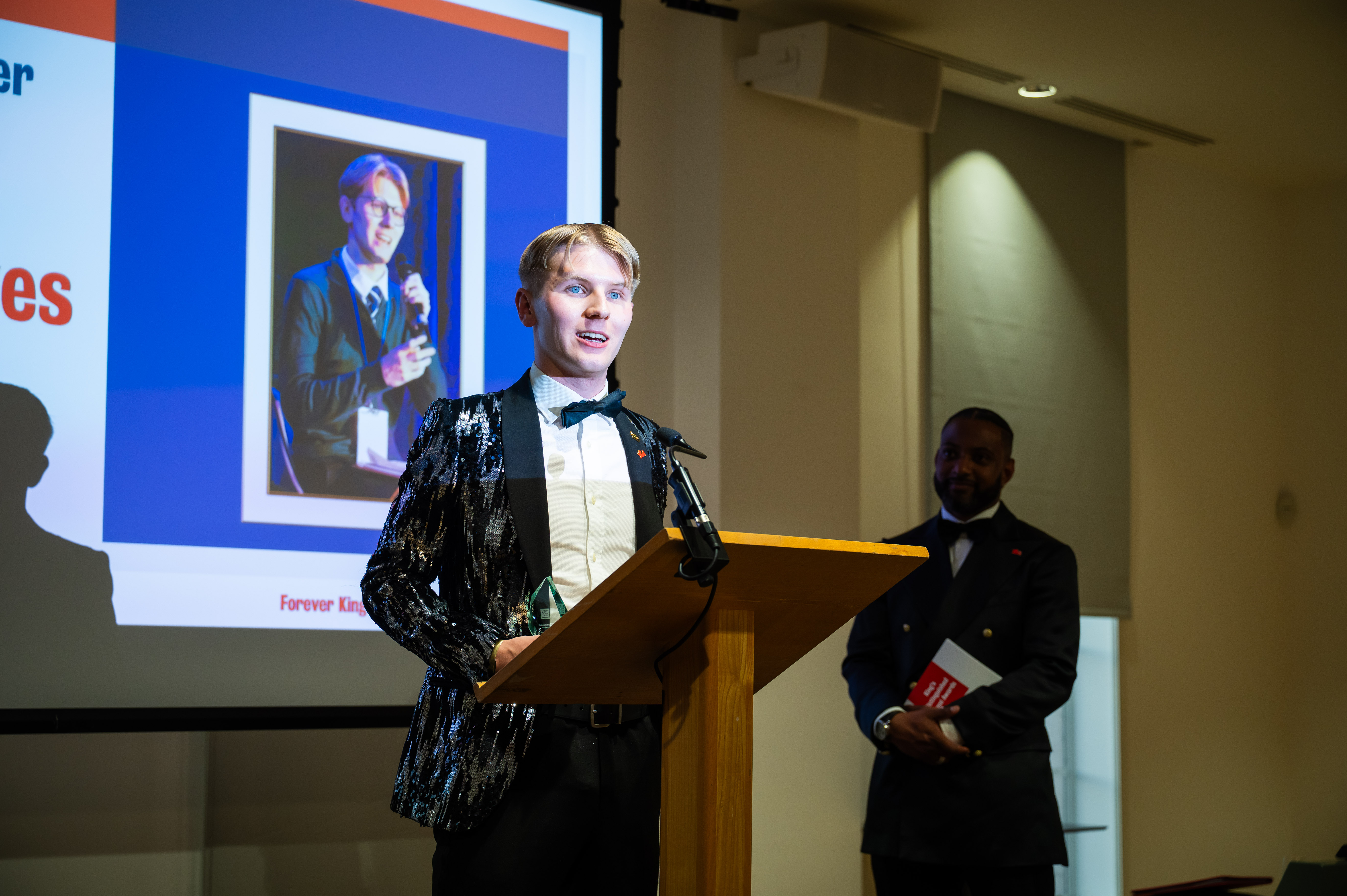 Student Jonathon Dawes  speaking to an audience behind a podium