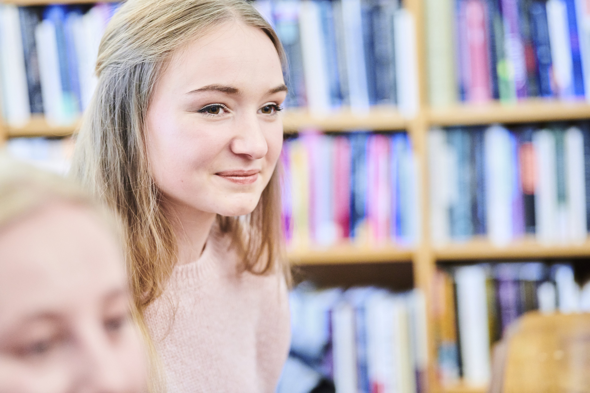 Students sitting in the library, listening to a talk