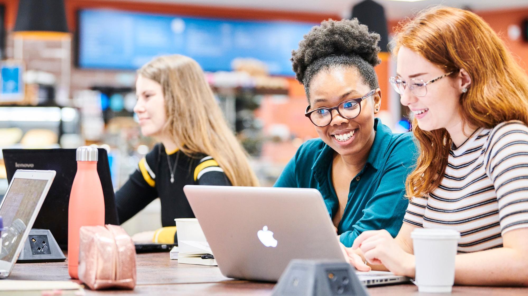 Students working on laptop in Bill Bryson Library café