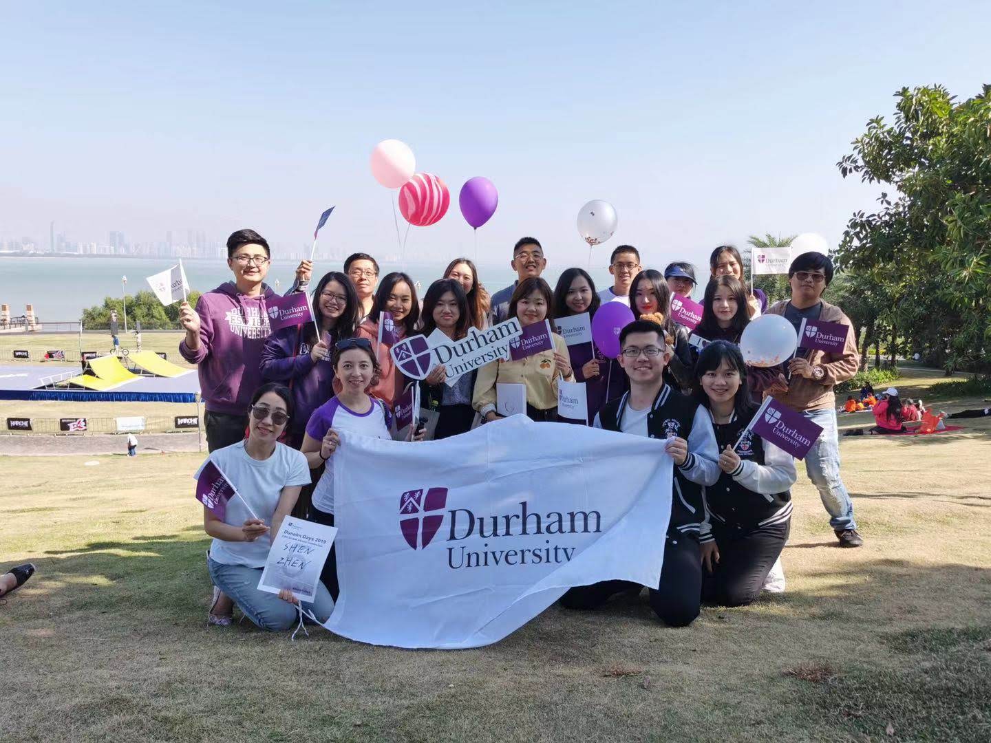 Group of alumni with Durham University banners