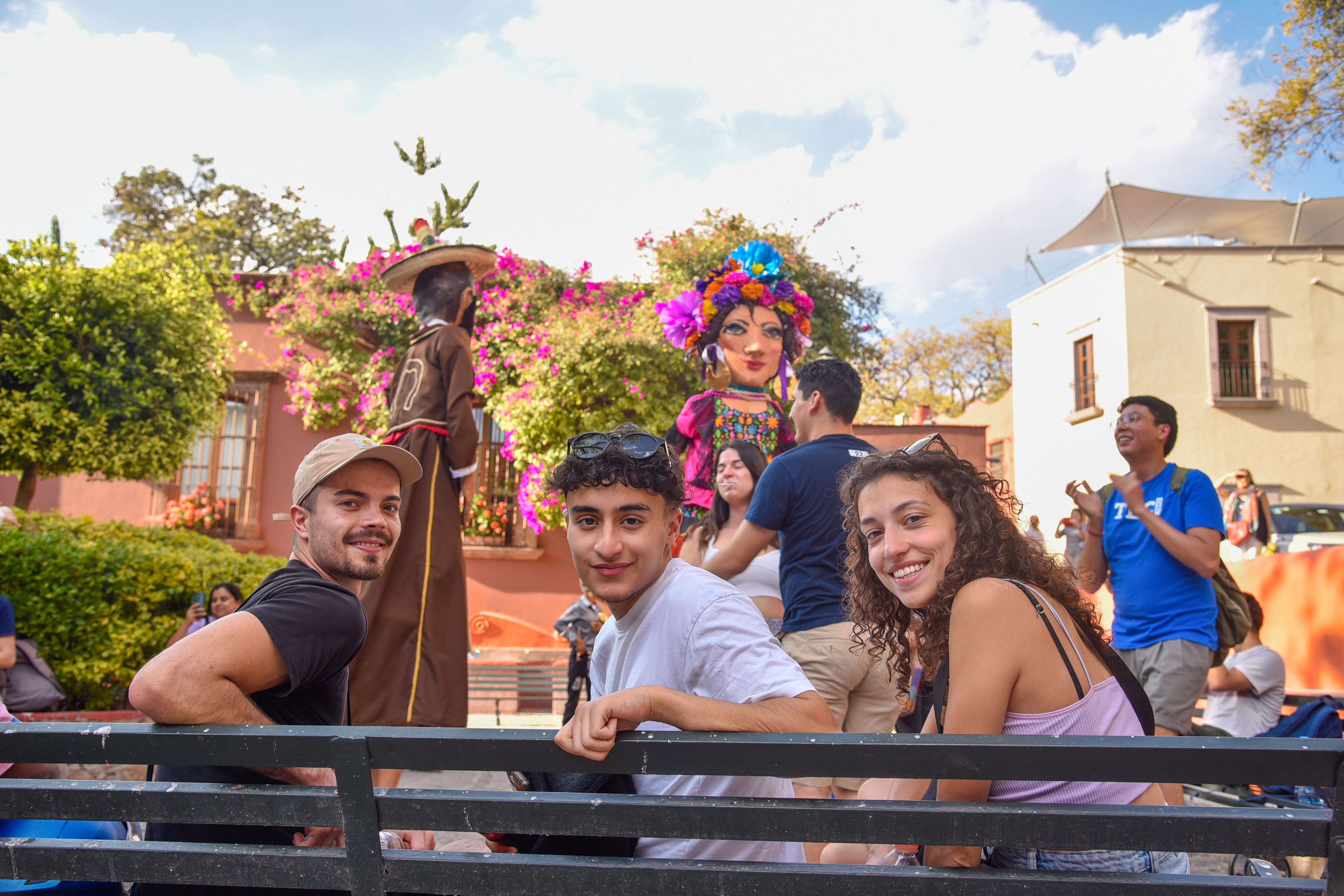 Three students sitting on a bench at a cultural event