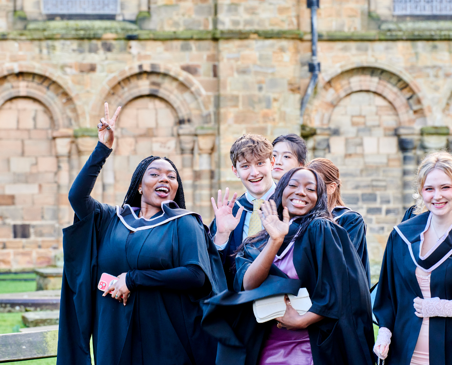 A group of students in graduation gowns outside Durham Cathedral