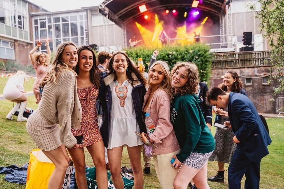 A group of female students in front of a stage