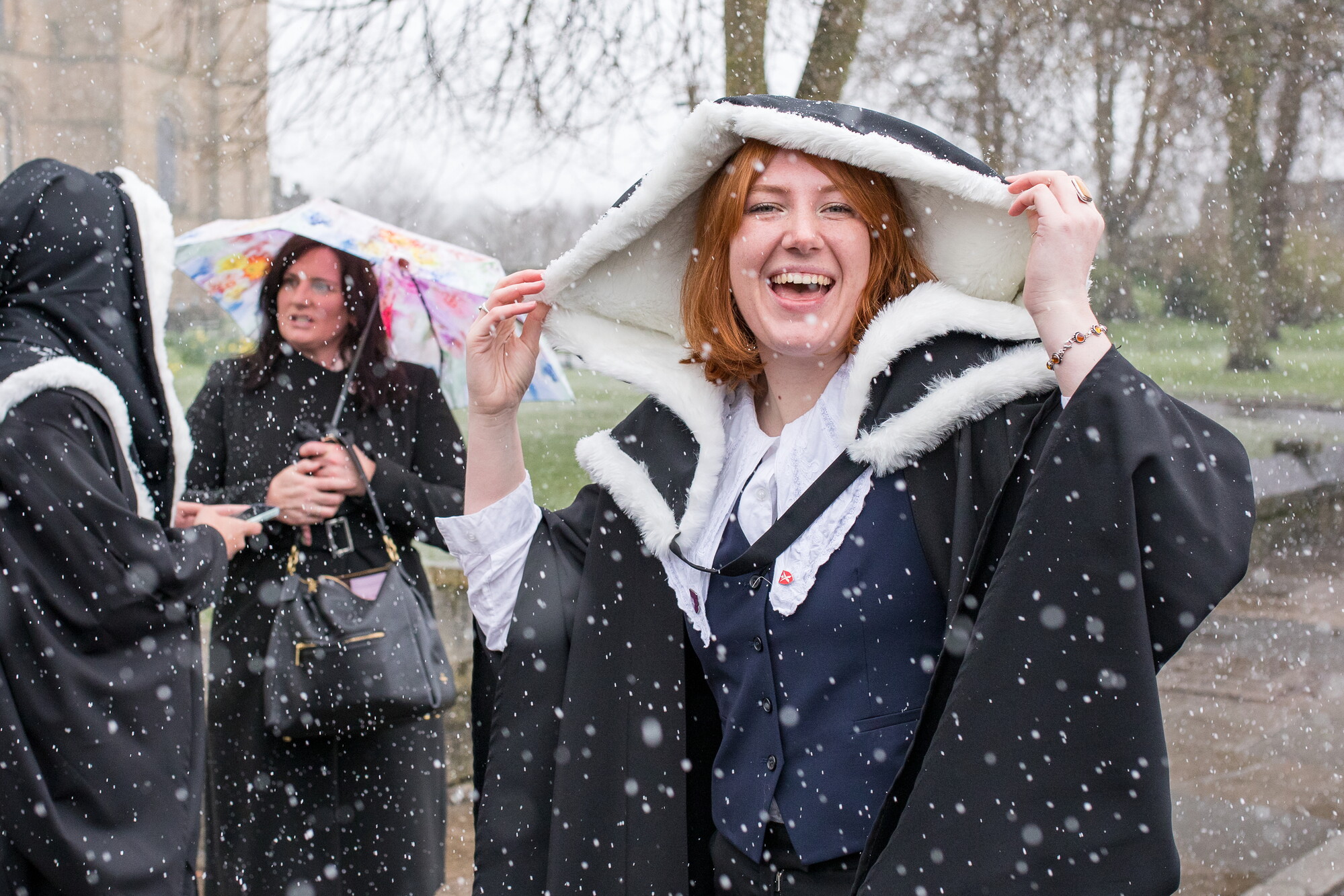 Graduands with their hoods up in the snow