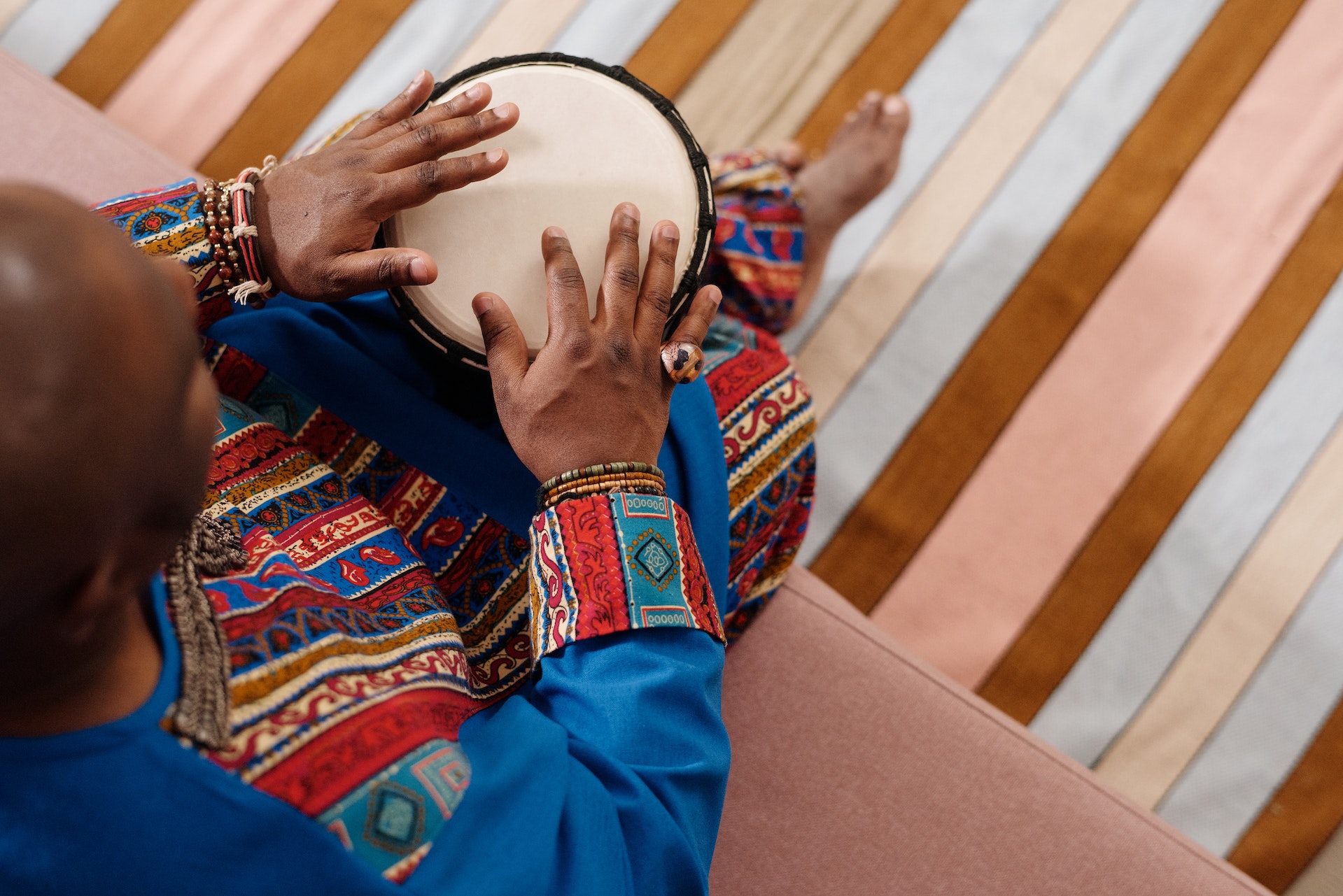 person playing a djembe or an African drum