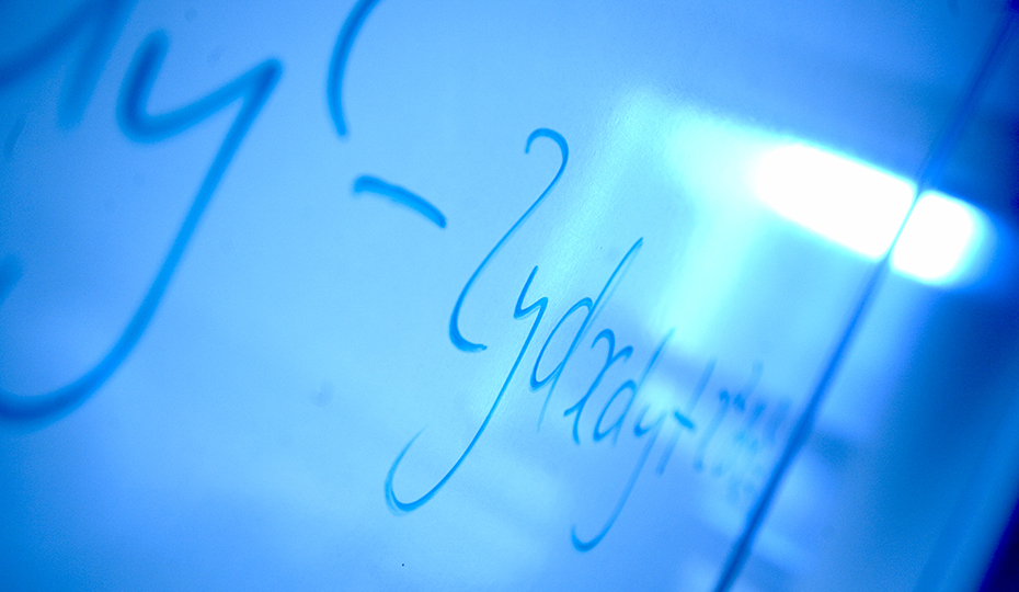 A mathematical equation on a wipe board