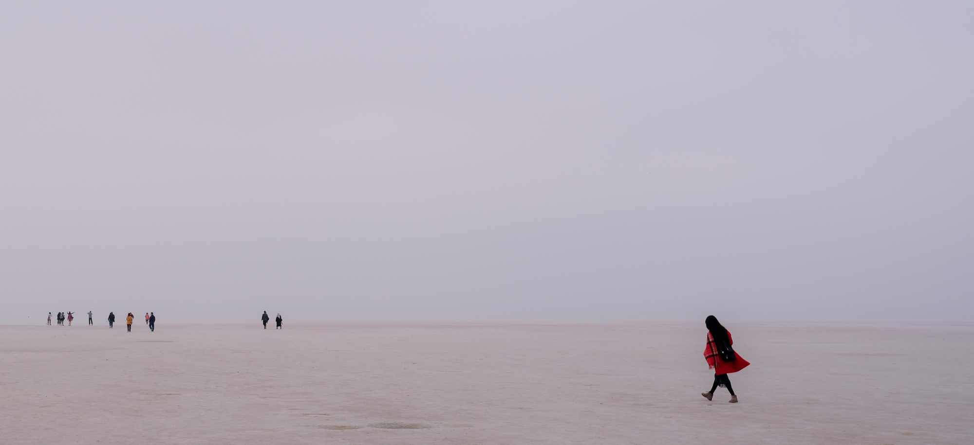 People walking across the desert.