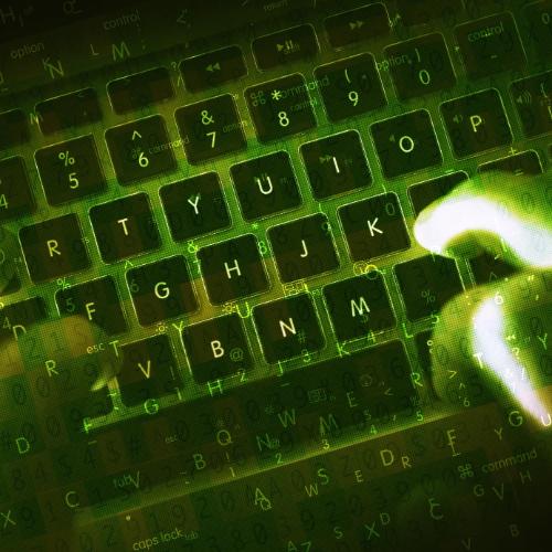 Hands typing on dark keyboard