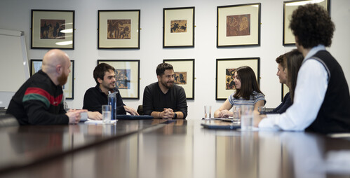 Staff from the International, Engagement & Careers team along with an academic sit at a round boardoom style table