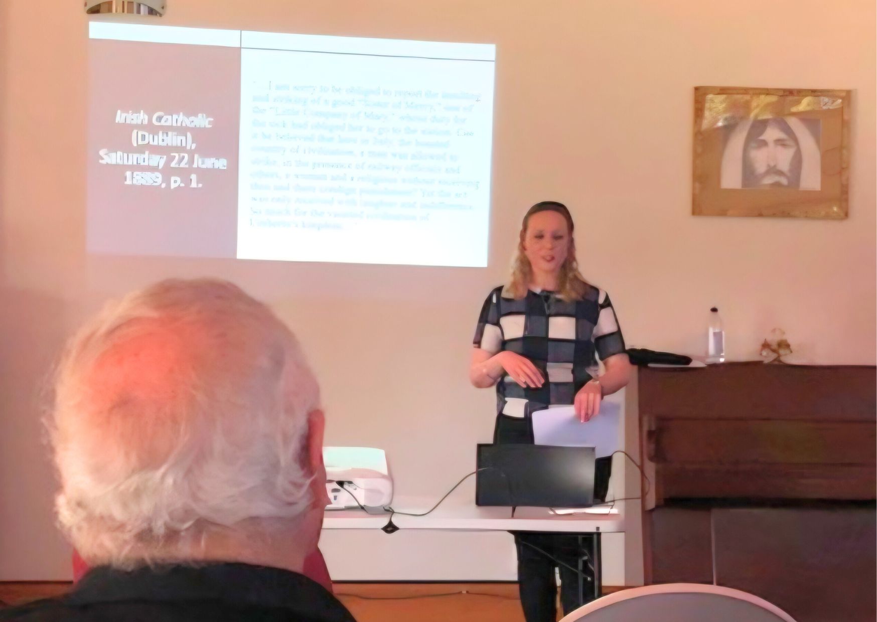 Image of a woman giving a presentation.