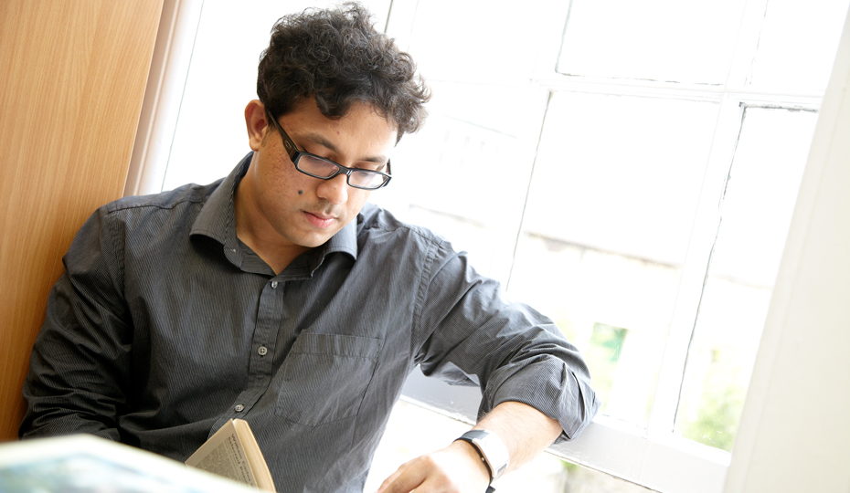 A person sitting by a window reading a book