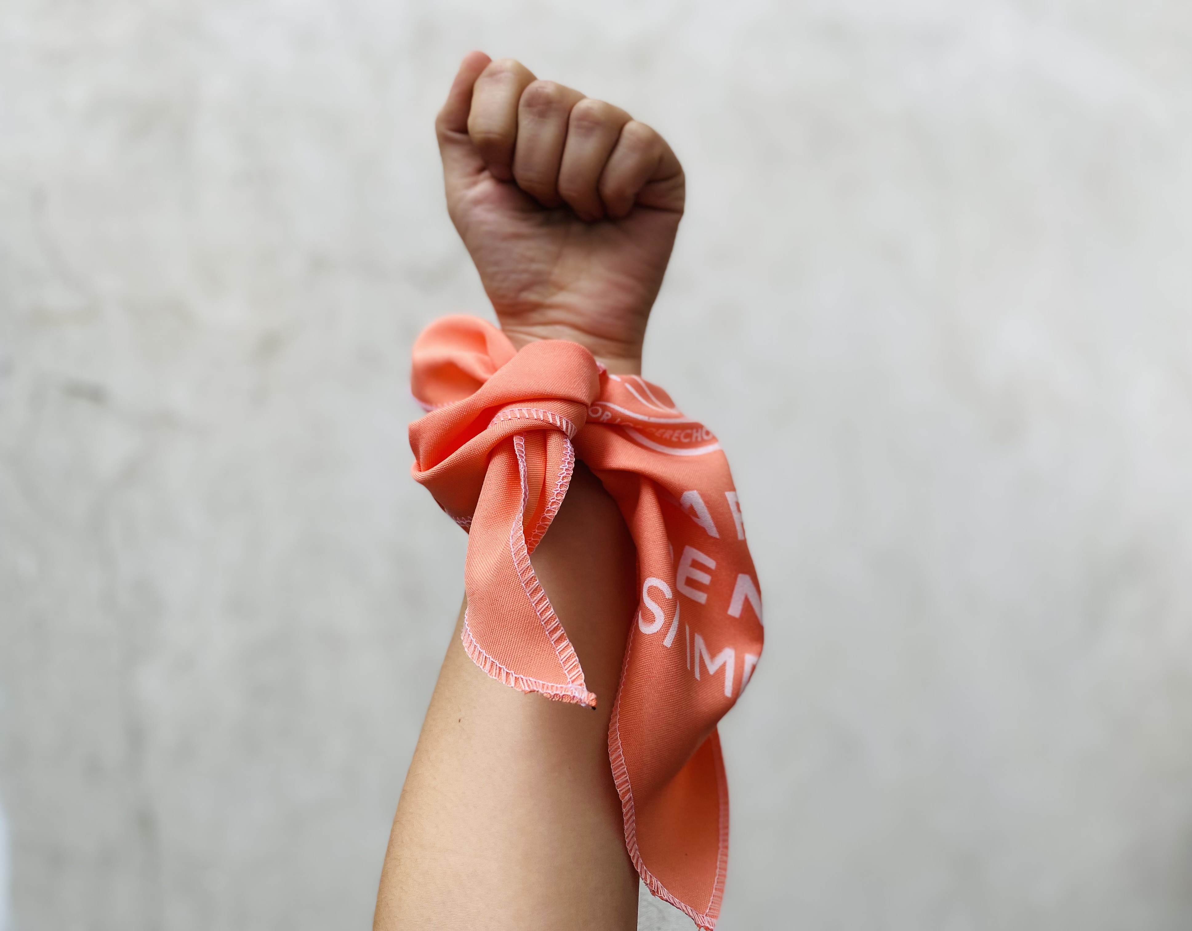 a hand holding the scarf used during the legislative debate on the Adriana Law in Chile
