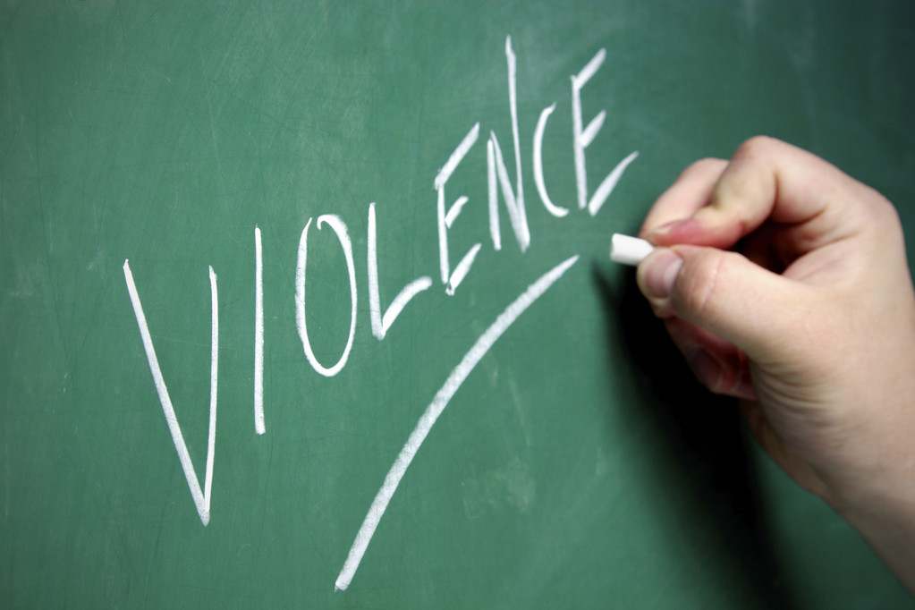 The word violence written in chalk on a board