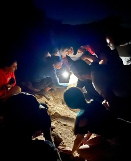 People with torches looking at Excavation