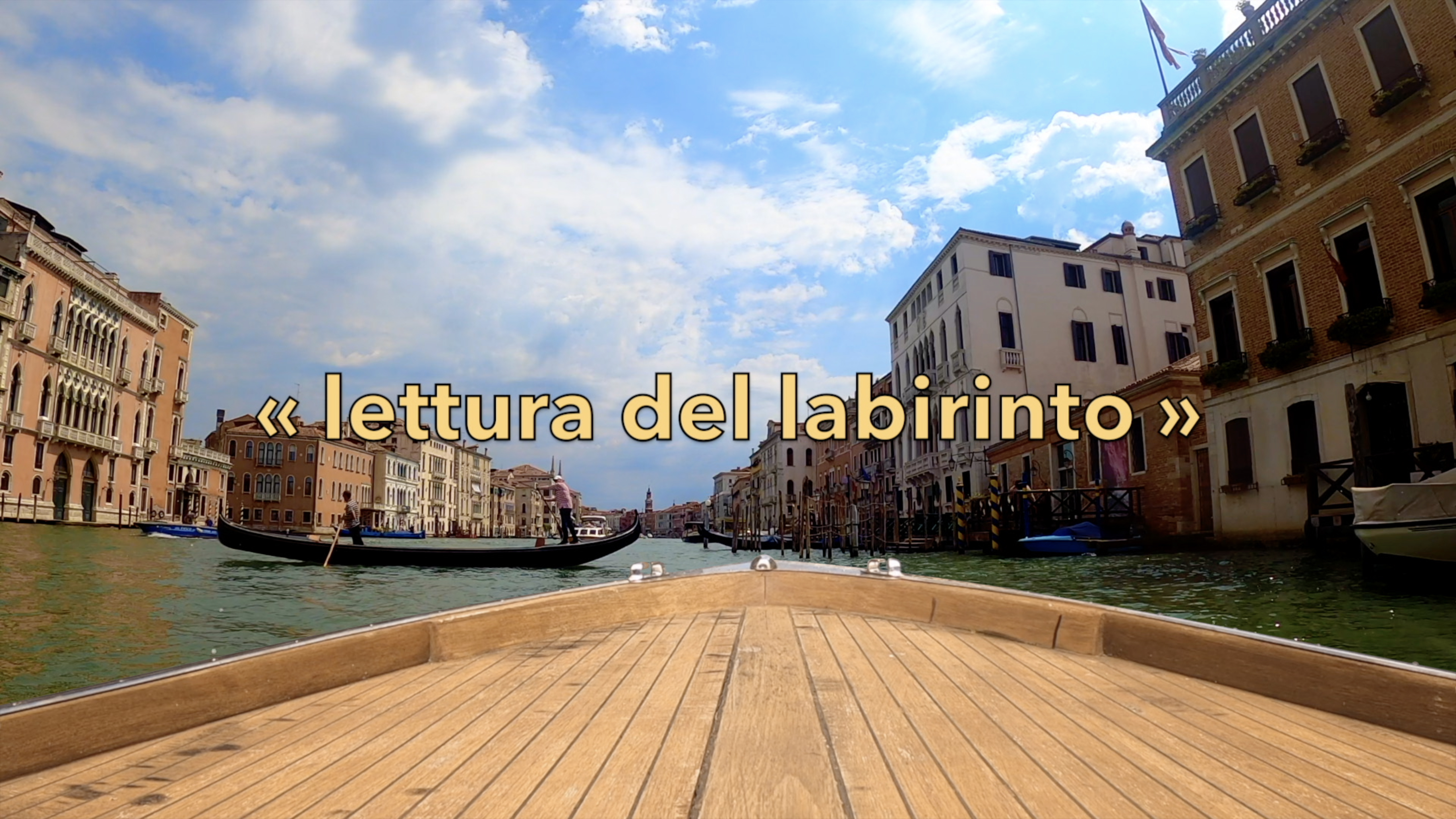 A picture of Venetian Canal taken from a boat, with other boats and houses visible. Text 