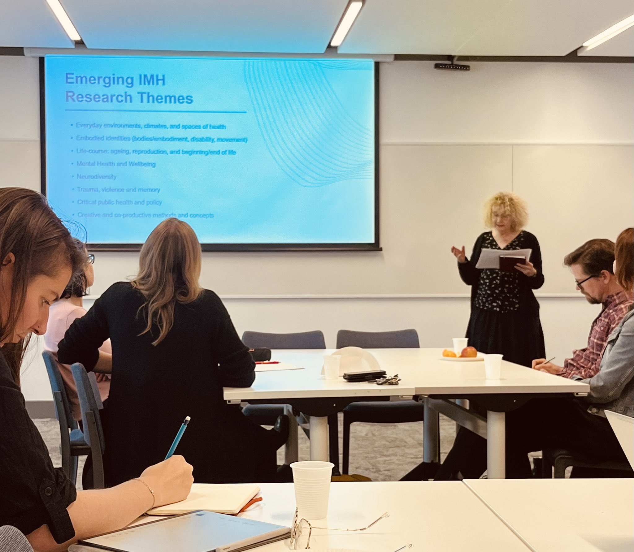 IMH Co-Director Corinne Saunders welcomes IMH Fellows, standing in front of a presentation titled 