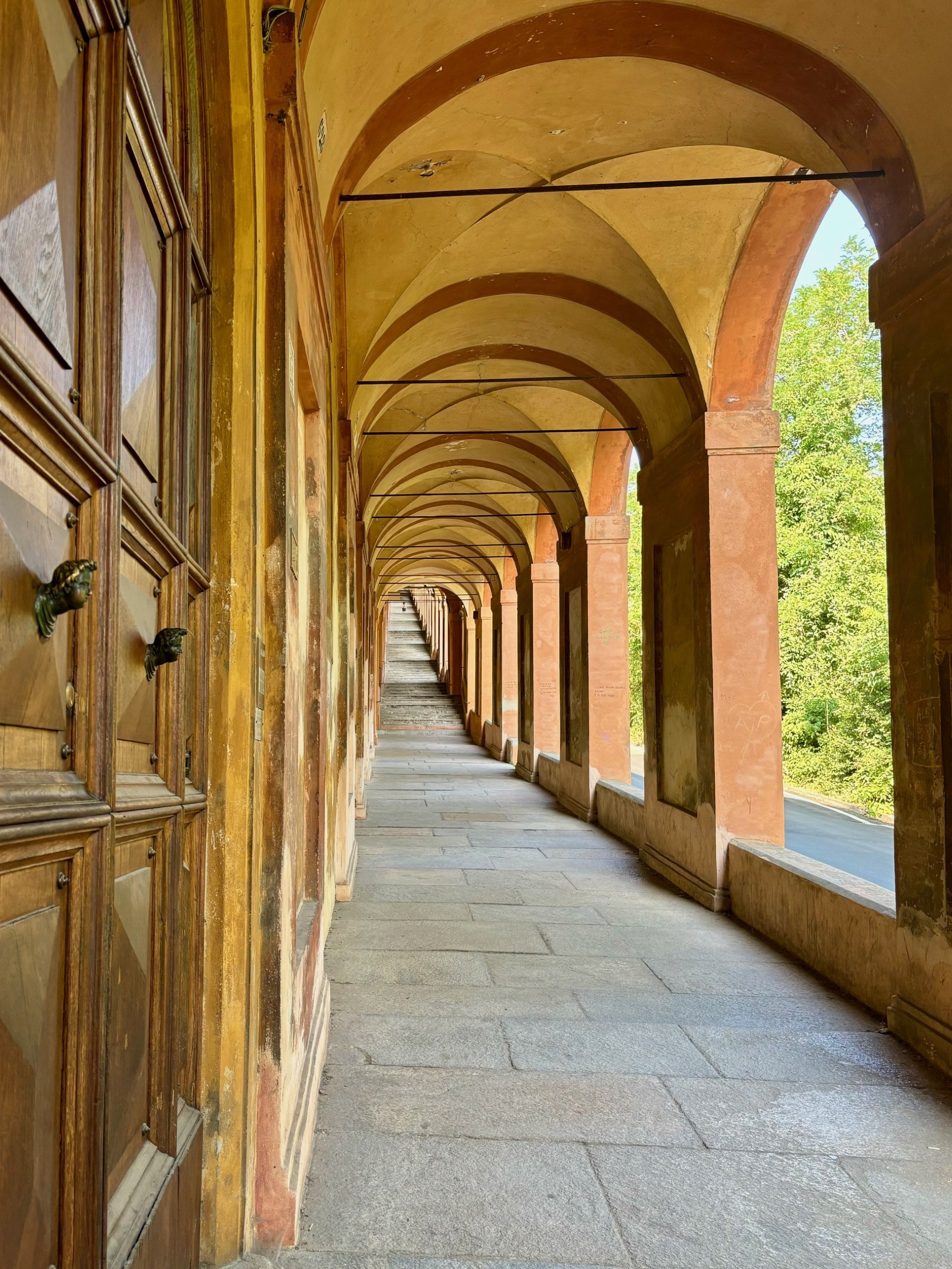 A long corridor with arched ceiling and orange pillars