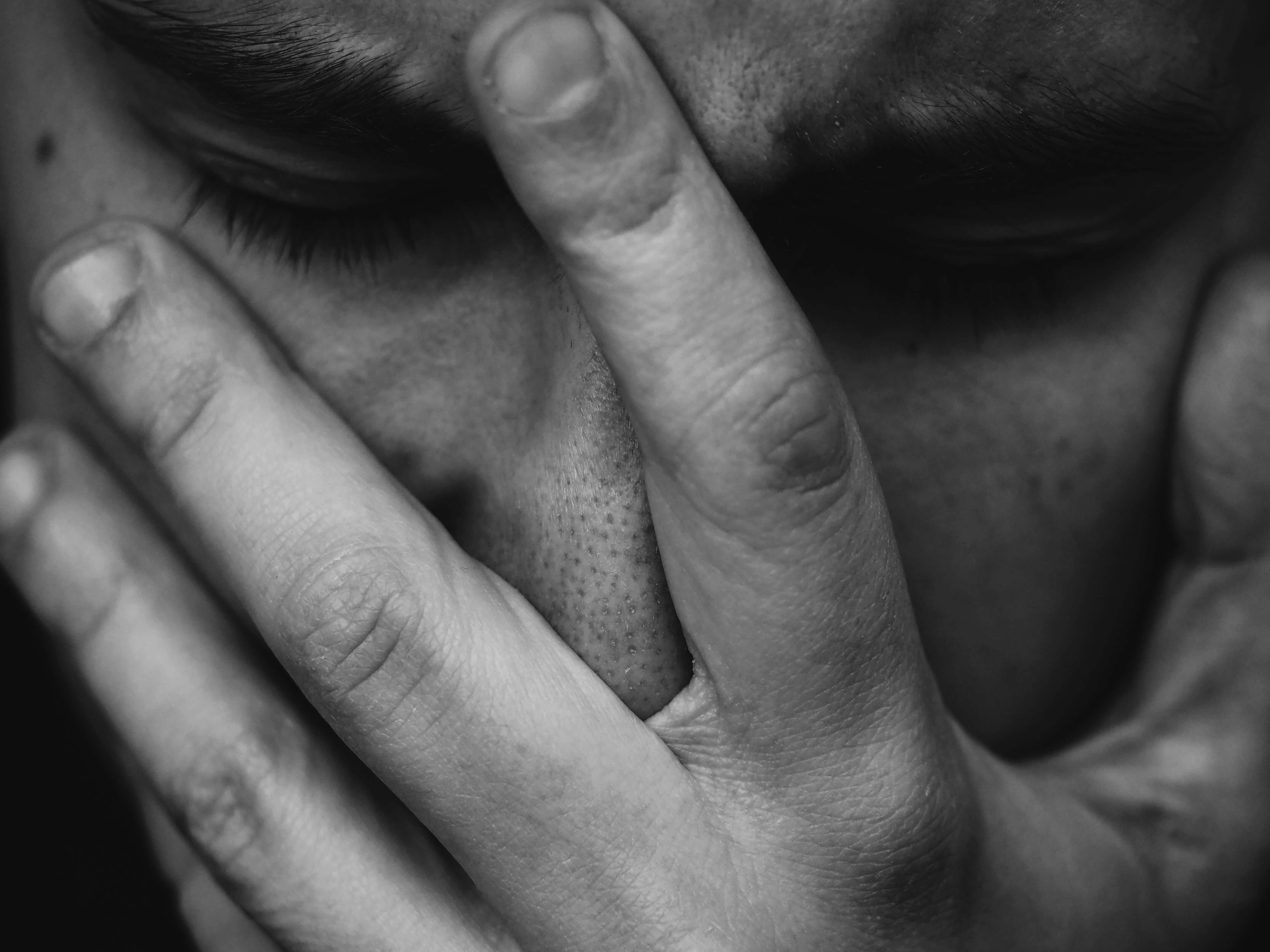 A black and white photograph of a man in pain