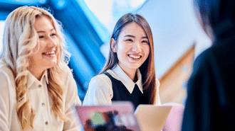 Two female students and a laptop