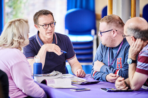 Teachers and staff talking around table at teacher conference