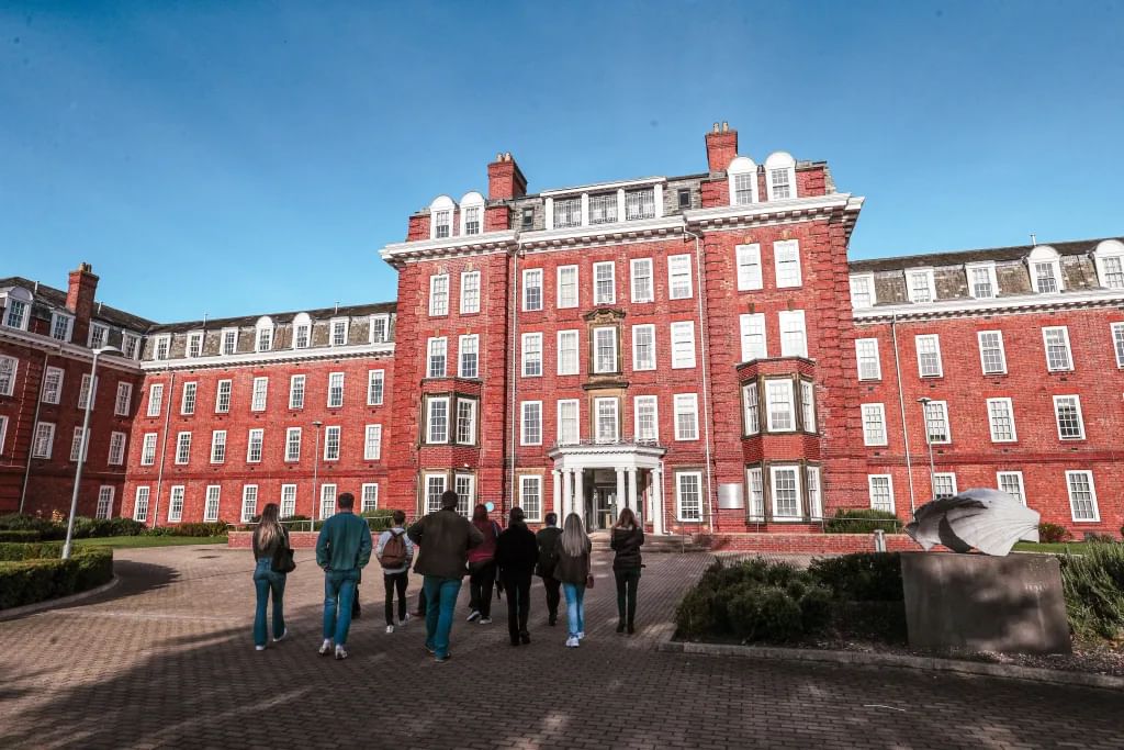A group of ten visitors approaching Ustinov college.