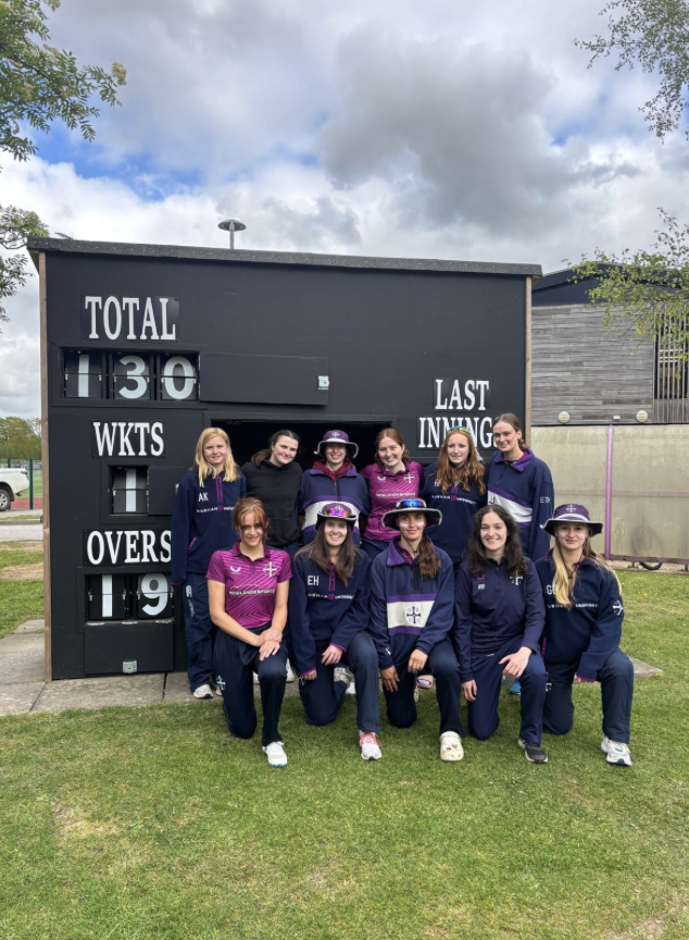 A group of Team Durham athletes standing in front of score board.