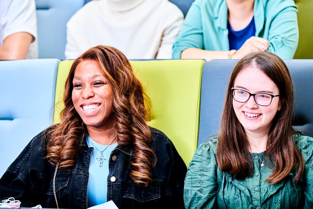 Two female students sat in a lecture theatre