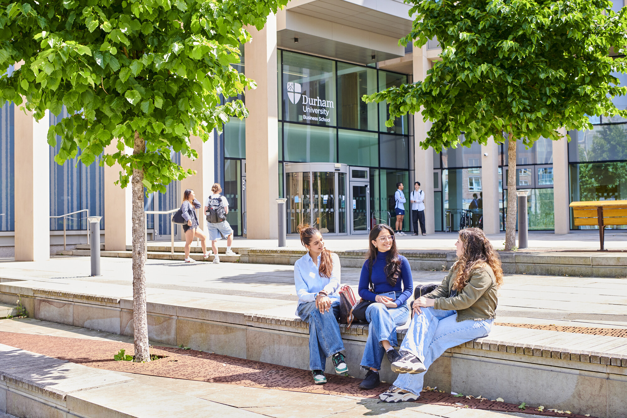 Three students sitting outside the Waterside Building