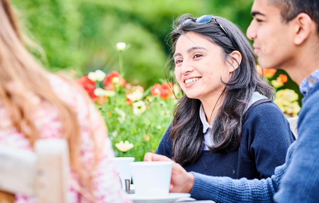 Students enjoying the Botanic Garden at café benches