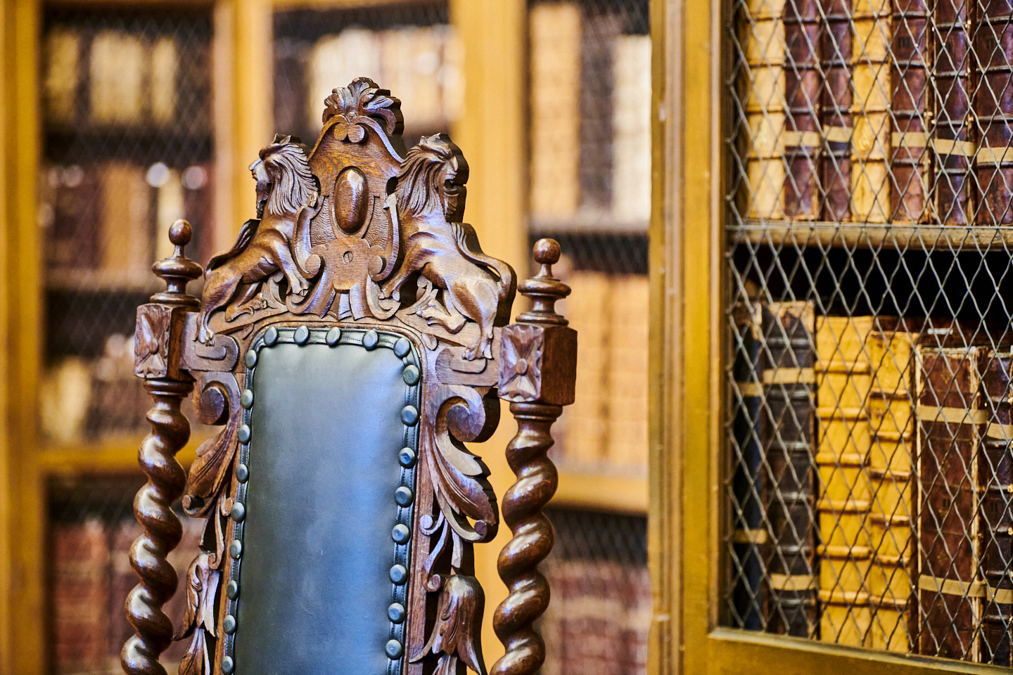 Close up of carved wooden chair in front of Cosin's Library bookcases
